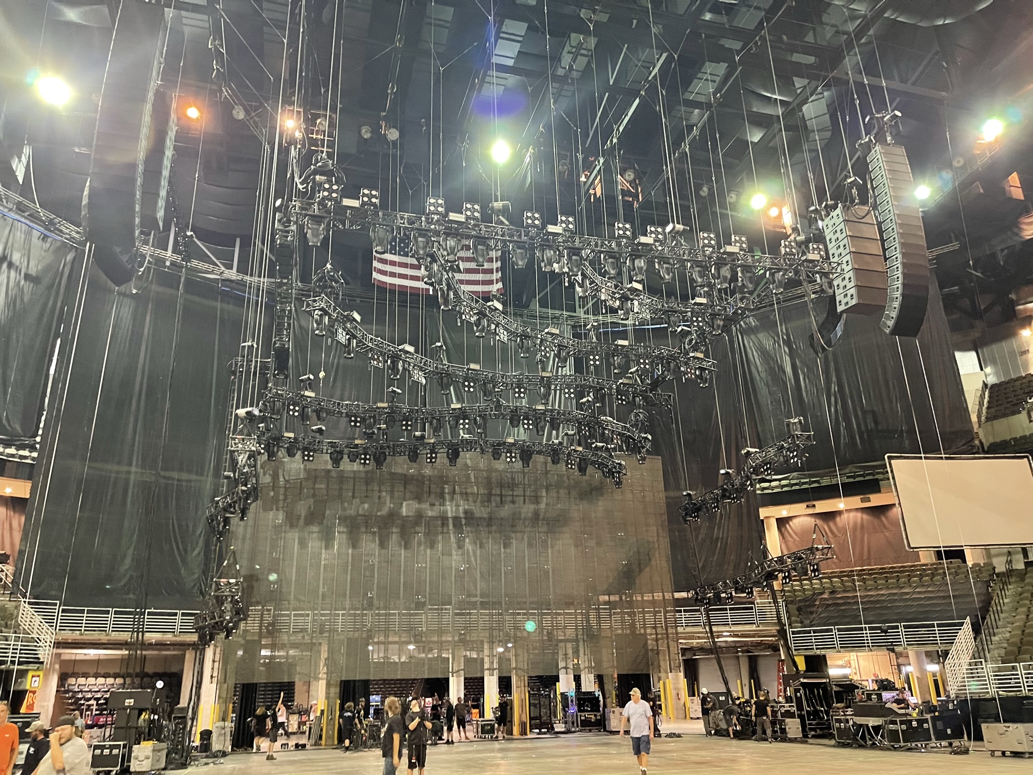 Flown PA, lighting truss, and video wall rigged above an arena stage